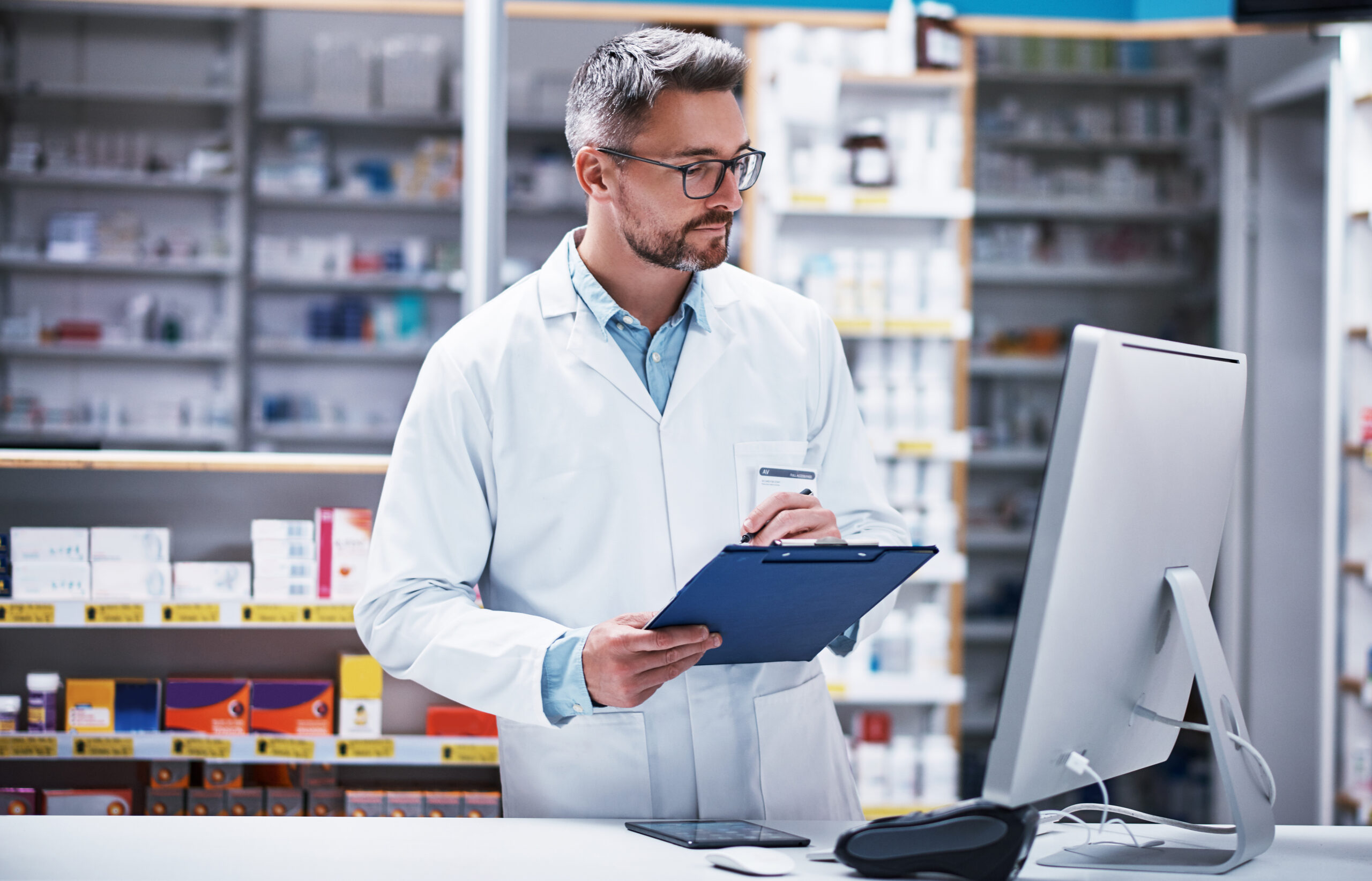 Shot of a mature pharmacist writing on a clipboard in a pharmacy